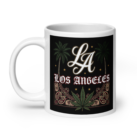 A white ceramic mug with a black wrap-around graphic featuring the text 'LA Los Angeles' in white, green palm trees, a green cannabis leaf, and ornate gold decorative elements on a black background.