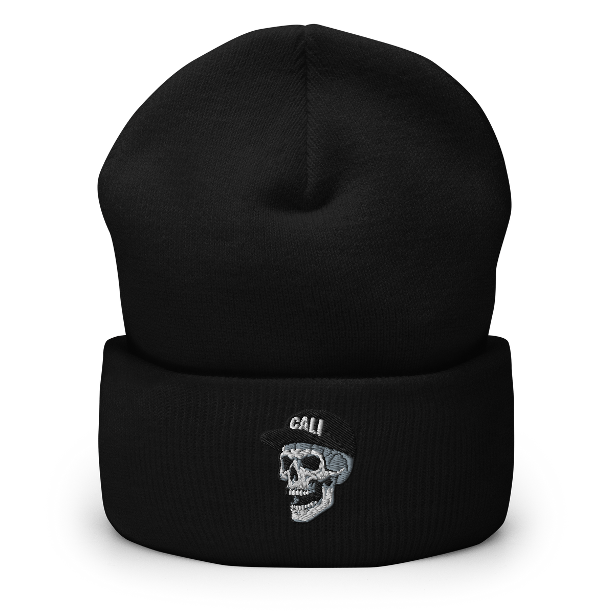 A black knit cuffed beanie hat featuring an embroidered skull wearing a small black hat with the word 'CALI' in white, shown on a clean white background.