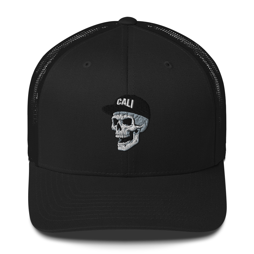A black trucker-style cap with a curved brim and black mesh back panels, featuring an embroidered front graphic of a white and gray skull wearing a cap with the word 'CALI' in white.