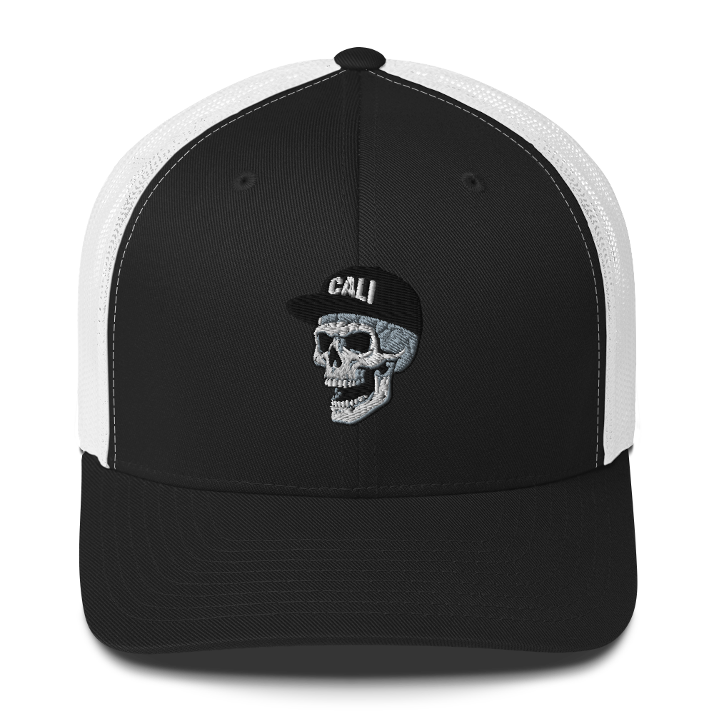 A black and white trucker hat featuring a white embroidered skull wearing a black cap with 'CALI' on the front, set against a plain white background.