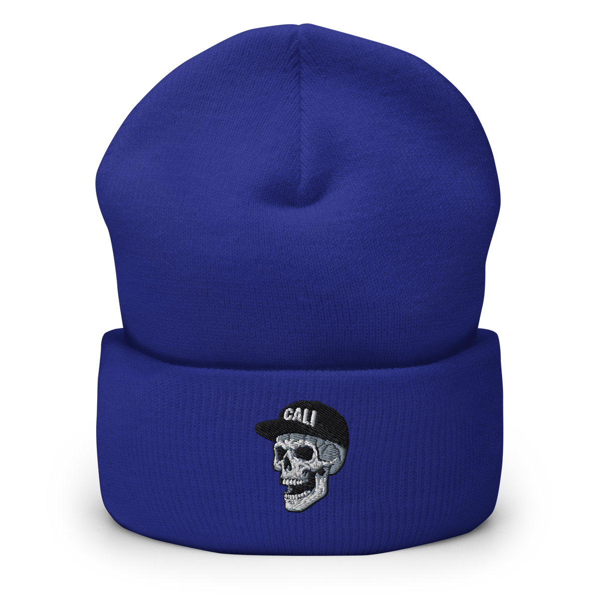 A royal blue knit beanie with a folded cuff, featuring an embroidered skull wearing a black cap with the word 'CALI' on the front.
