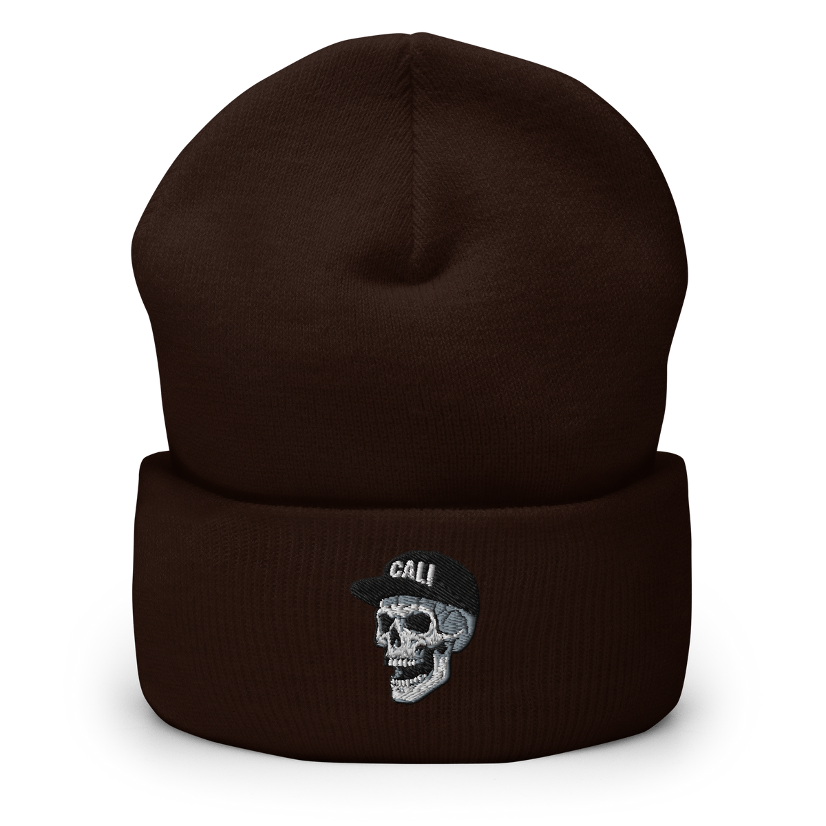 A dark brown ribbed knit beanie hat with a folded cuff, featuring an embroidered skull wearing a black cap with the text 'CALI' in white.