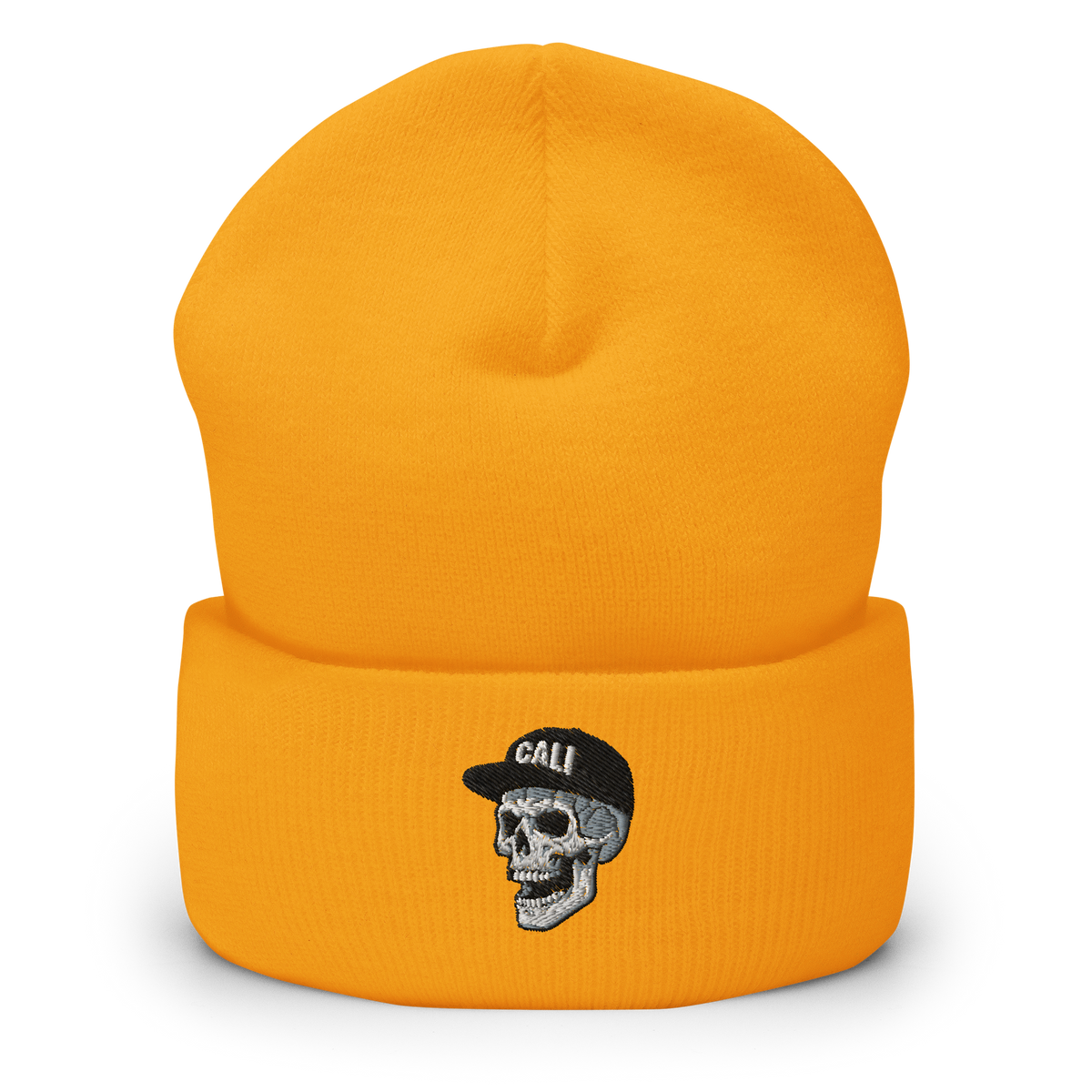 A gold knit beanie hat with a folded cuff, featuring an embroidered skull wearing a black cap with the word 'Cali' in white.