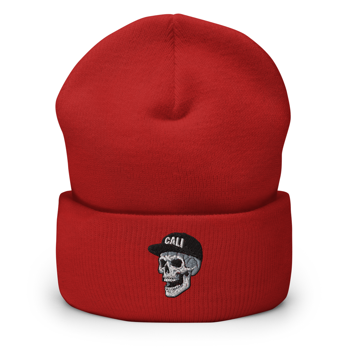 A red knit beanie hat with a folded cuff featuring an embroidered skull wearing a black cap with the word 'CALI' in white.