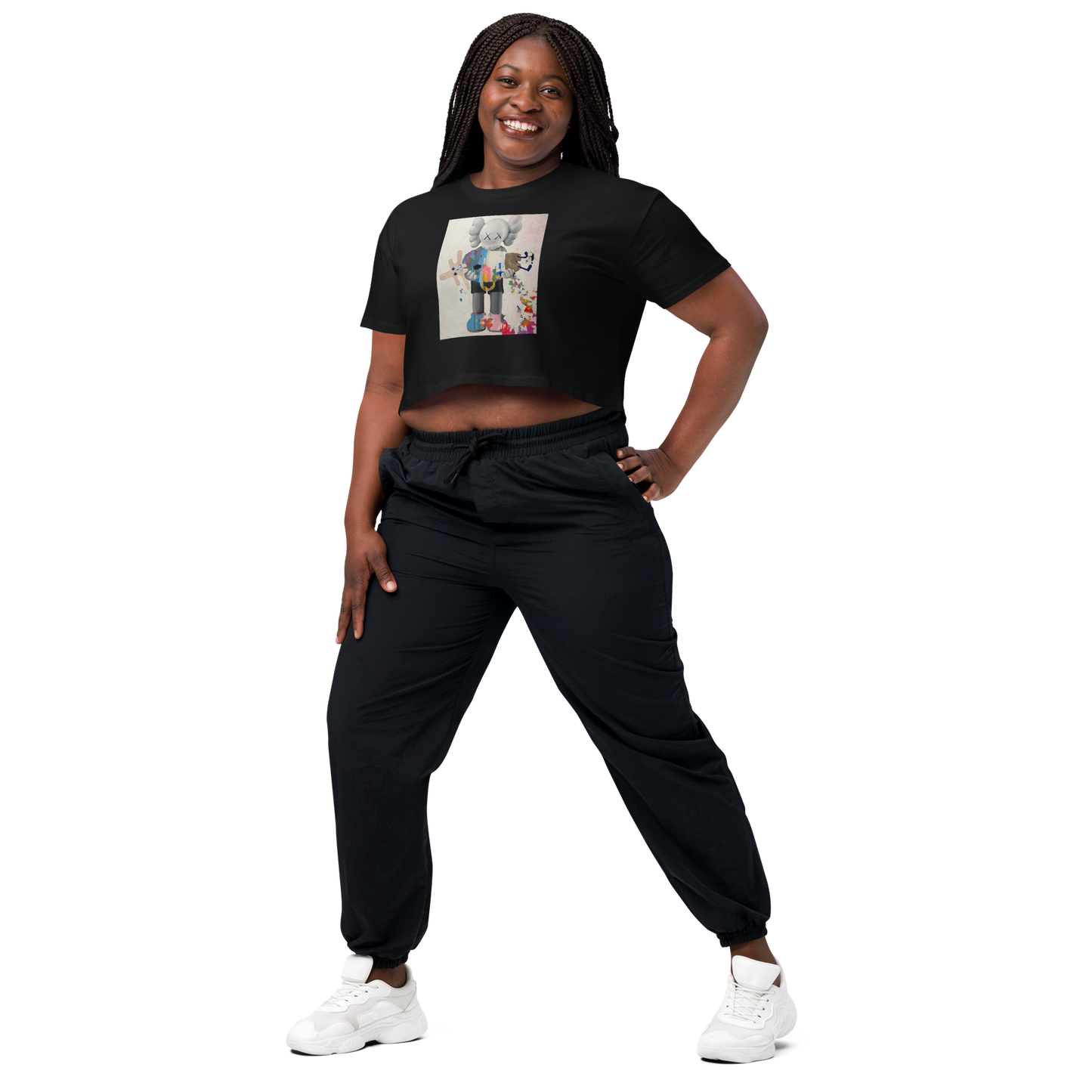 A woman modeling a black short-sleeve crop top with a colorful graphic print on the front, paired with black jogger pants and white sneakers. Daniel Maltzman artist.