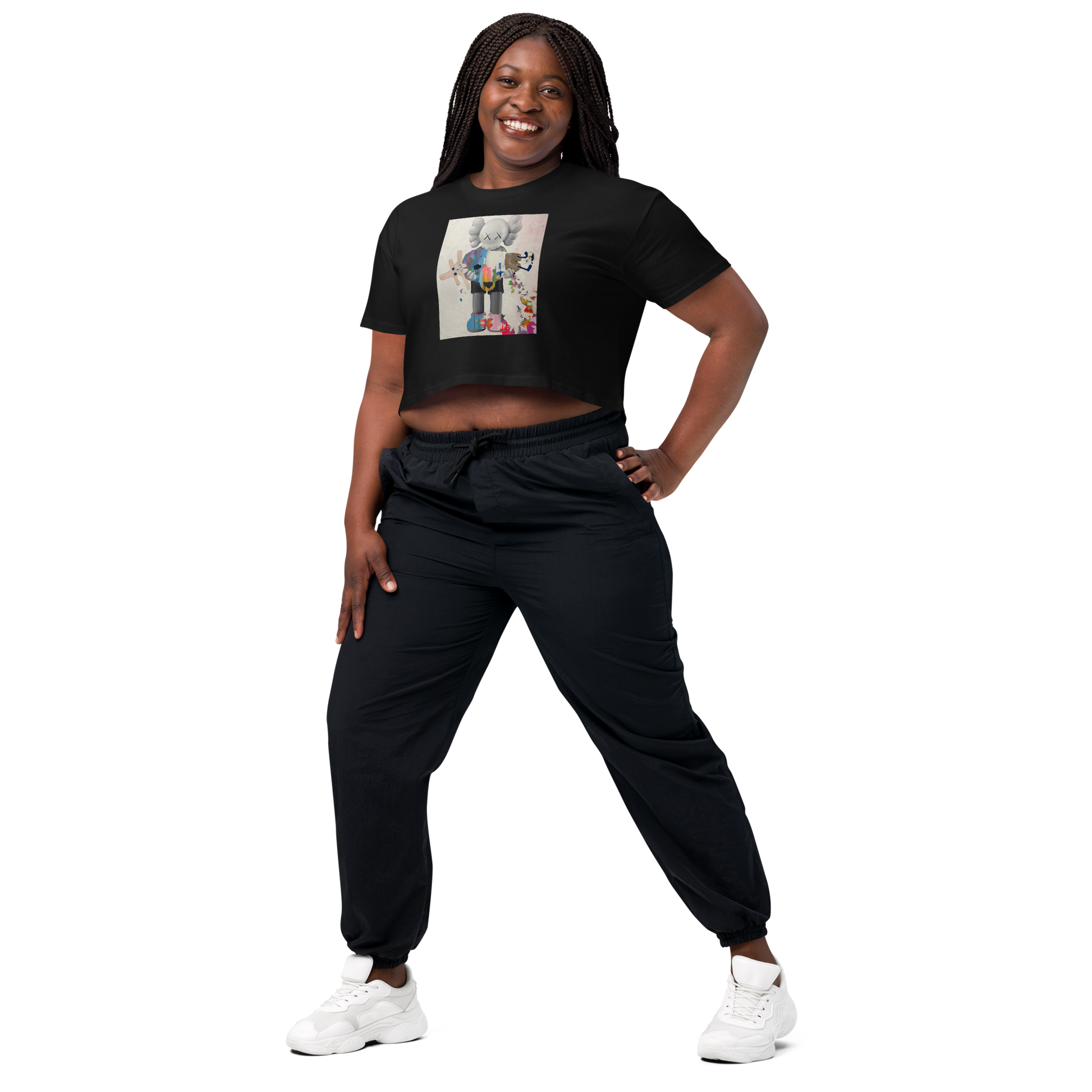 A woman modeling a black short-sleeve crop top with a colorful graphic print on the front, paired with black jogger pants and white sneakers. Daniel Maltzman artist.