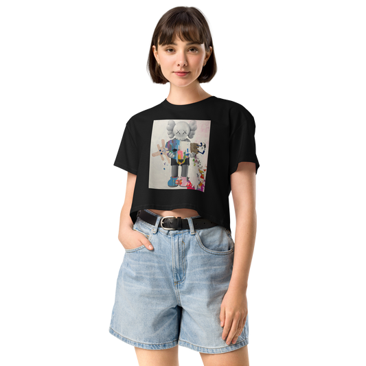 A woman modeling a black crop top t-shirt with a colorful graphic print of a cartoon character, paired with light-wash denim shorts. Daniel Maltzman artist. 