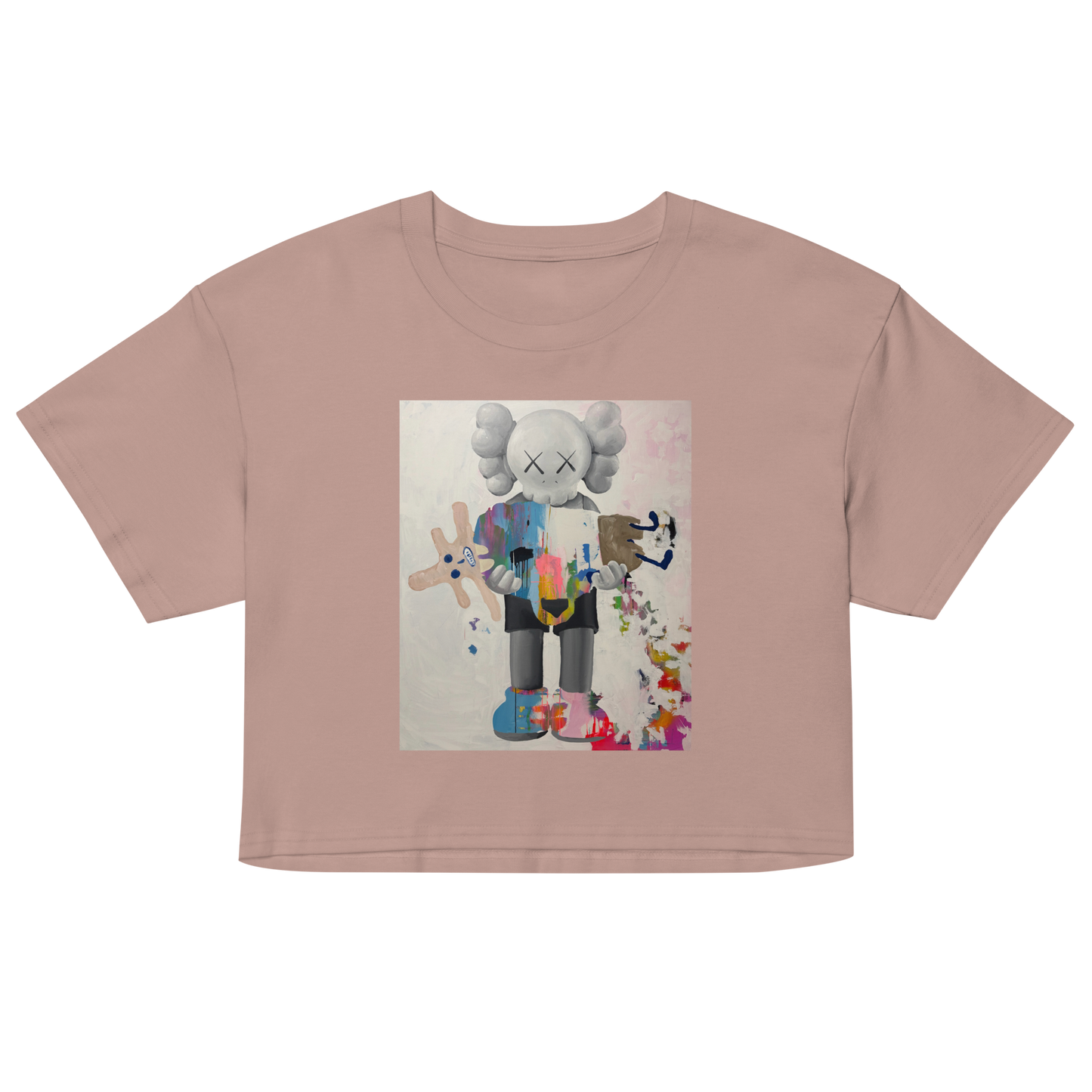 A dusty pink short-sleeve crop top t-shirt featuring a colorful graphic print of a stylized cartoon character resembling KAWS, Daniel Maltzman artist.