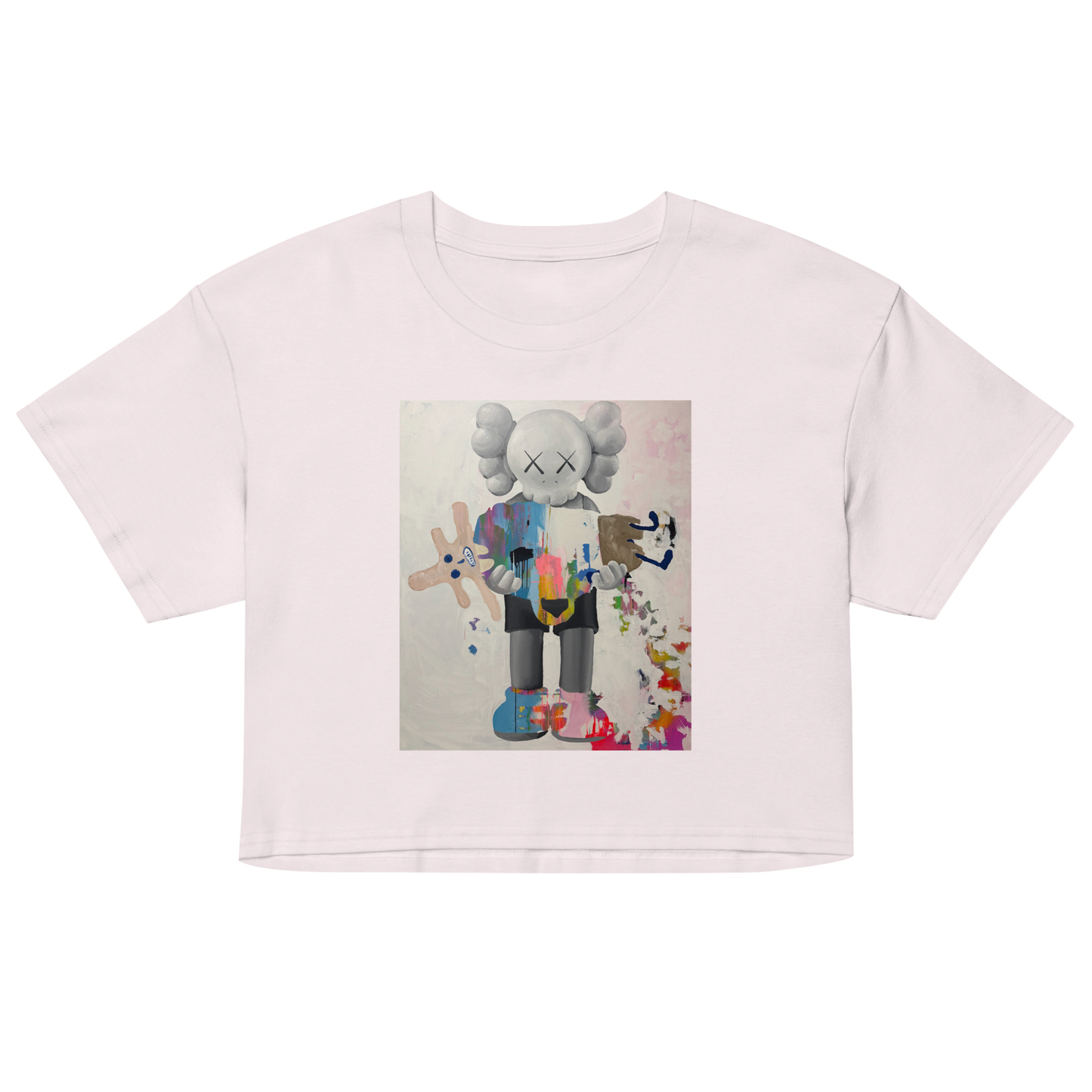 A light pink short-sleeve crop top t-shirt featuring a colorful graphic print of a stylized cartoon character resembling KAWS, Daniel Maltzman artist.