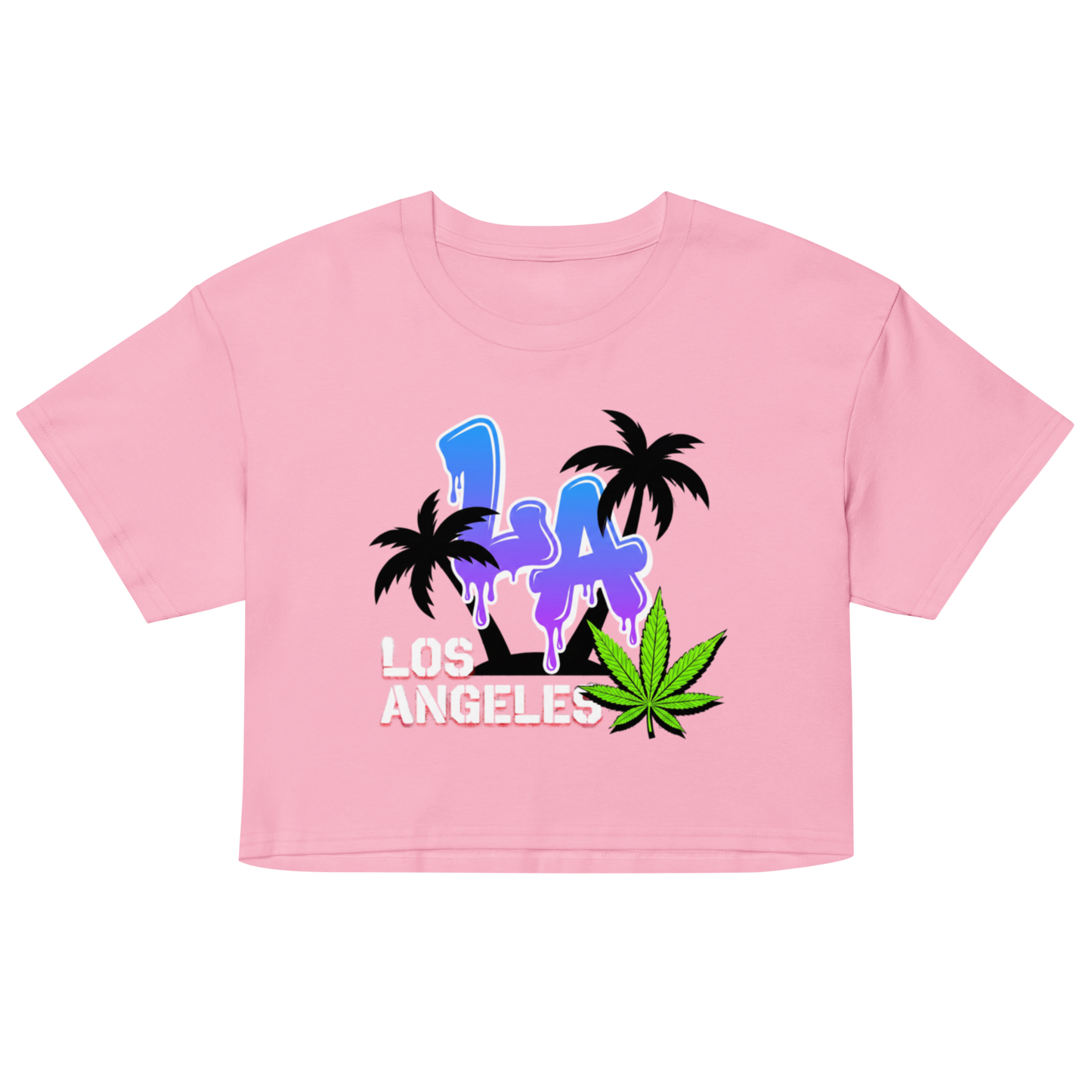 A light pink short-sleeve crop top t-shirt featuring a colorful graphic print on the front with the text 'LA LOS ANGELES' in blue, purple, and white, flanked by black palm trees and a green cannabis leaf.