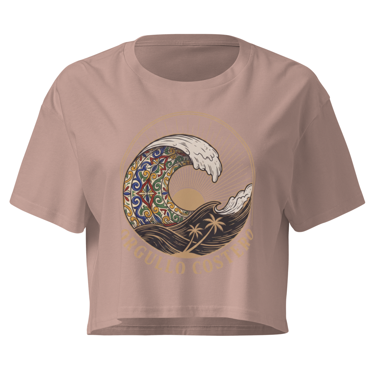 A cropped short-sleeve t-shirt in a dusty rose pink color, featuring a large graphic print of a stylized wave with a colorful mandala pattern, palm trees, and the text 'ORGULLO COSTERO' printed below the wave.