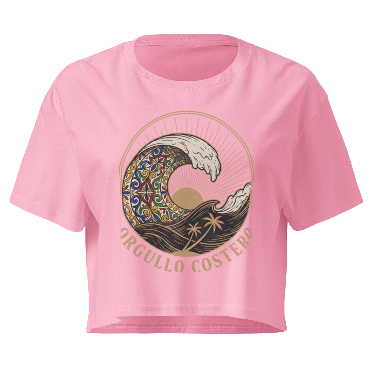 A pink short-sleeve crop top t-shirt featuring a large graphic print of a stylized wave with a mandala pattern, a sun, palm trees, and the text 'ORGULLO COSTERO' in gold.