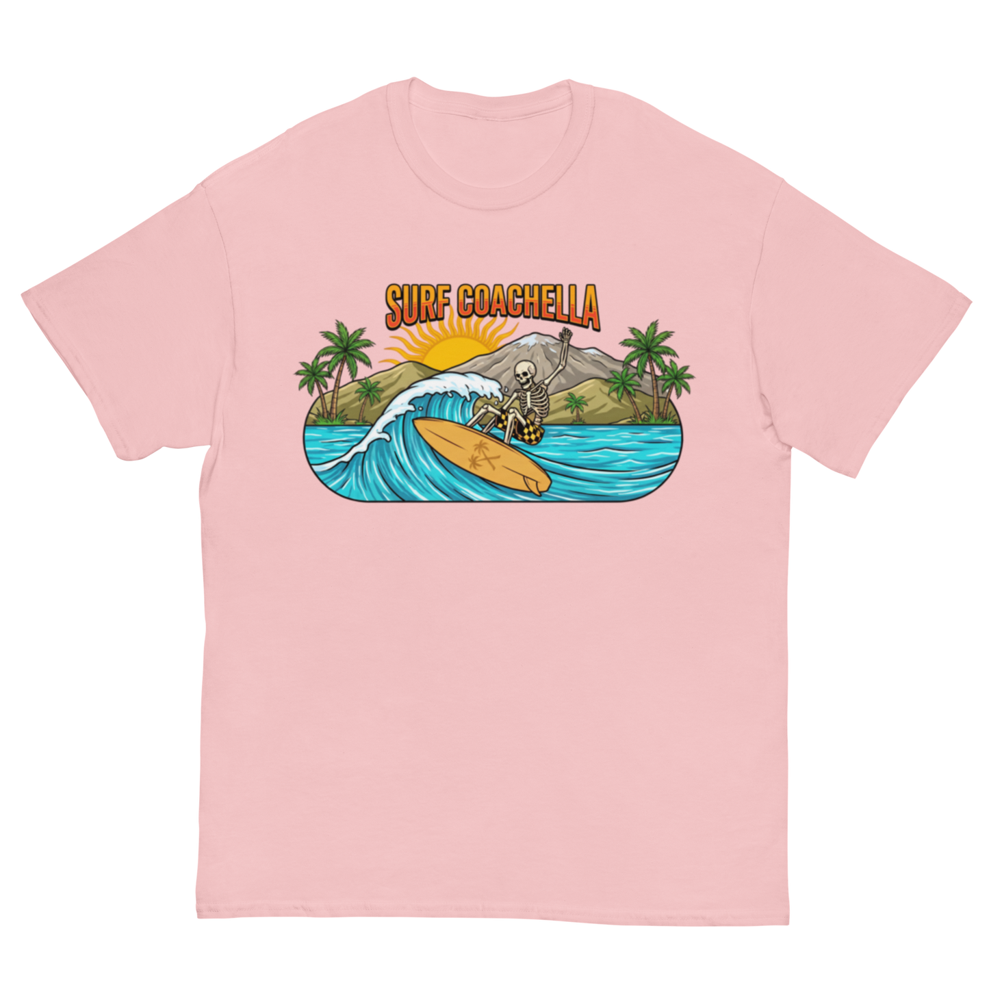 A light pink short-sleeve crewneck t-shirt featuring a colorful graphic print on the chest. The graphic shows a skeleton surfer riding a wave on a yellow surfboard, with palm trees, a mountain, a rising sun, and the text 'SURF COACHELLA' above it.