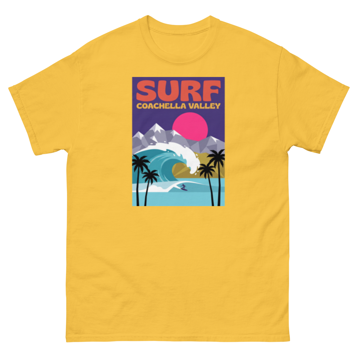 A yellow short-sleeve crewneck t-shirt featuring a retro-style graphic print on the chest that reads 'SURF COACHELLA VALLEY' above an illustration of a surf wave, mountains, palm trees, and a pink sun.