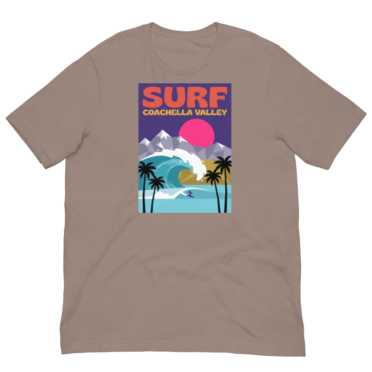 A taupe brown short-sleeve crewneck t-shirt featuring a colorful graphic print on the front with the text 'SURF COACHELLA VALLEY' and an illustration of a wave, mountains, palm trees, and a pink sun.