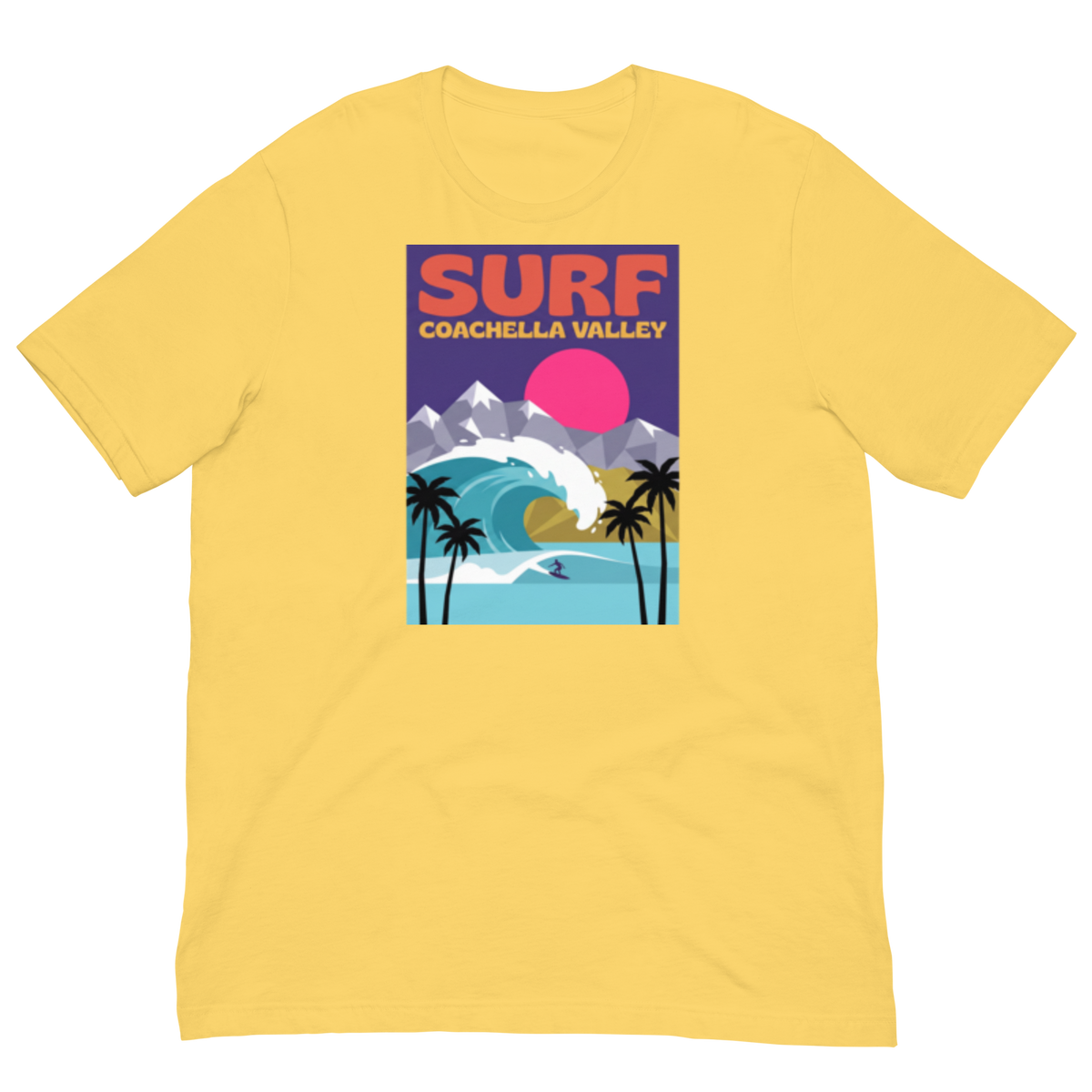 A yellow short-sleeve crewneck t-shirt featuring a colorful retro-style graphic print on the chest that reads 'SURF COACHELLA VALLEY' above an illustration of a surf wave, mountains, palm trees, and a pink sun.