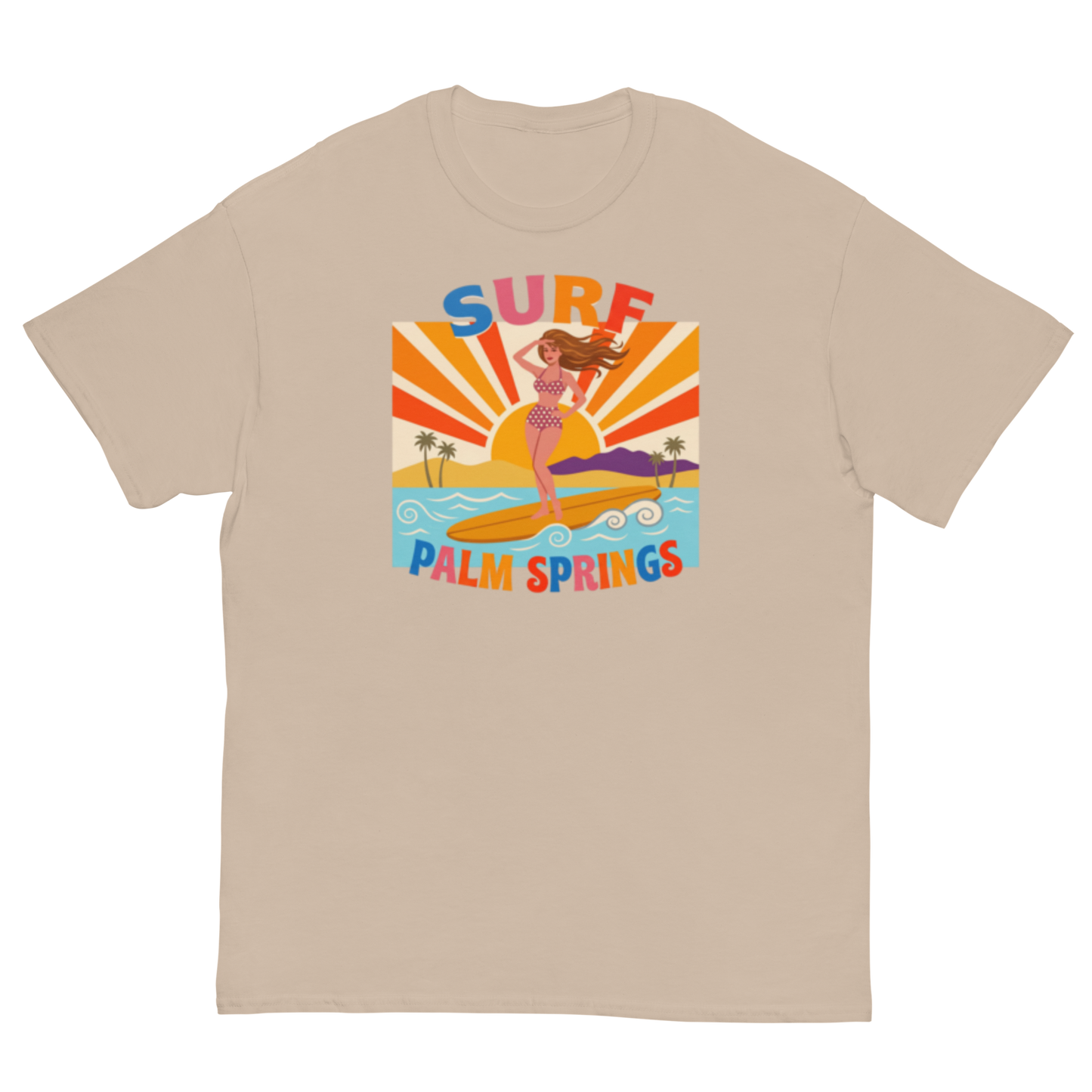 A beige crewneck t-shirt featuring a colorful retro graphic of a woman surfing on a beach with the text 'SURF PALM SPRINGS' in stylized multicolor lettering.