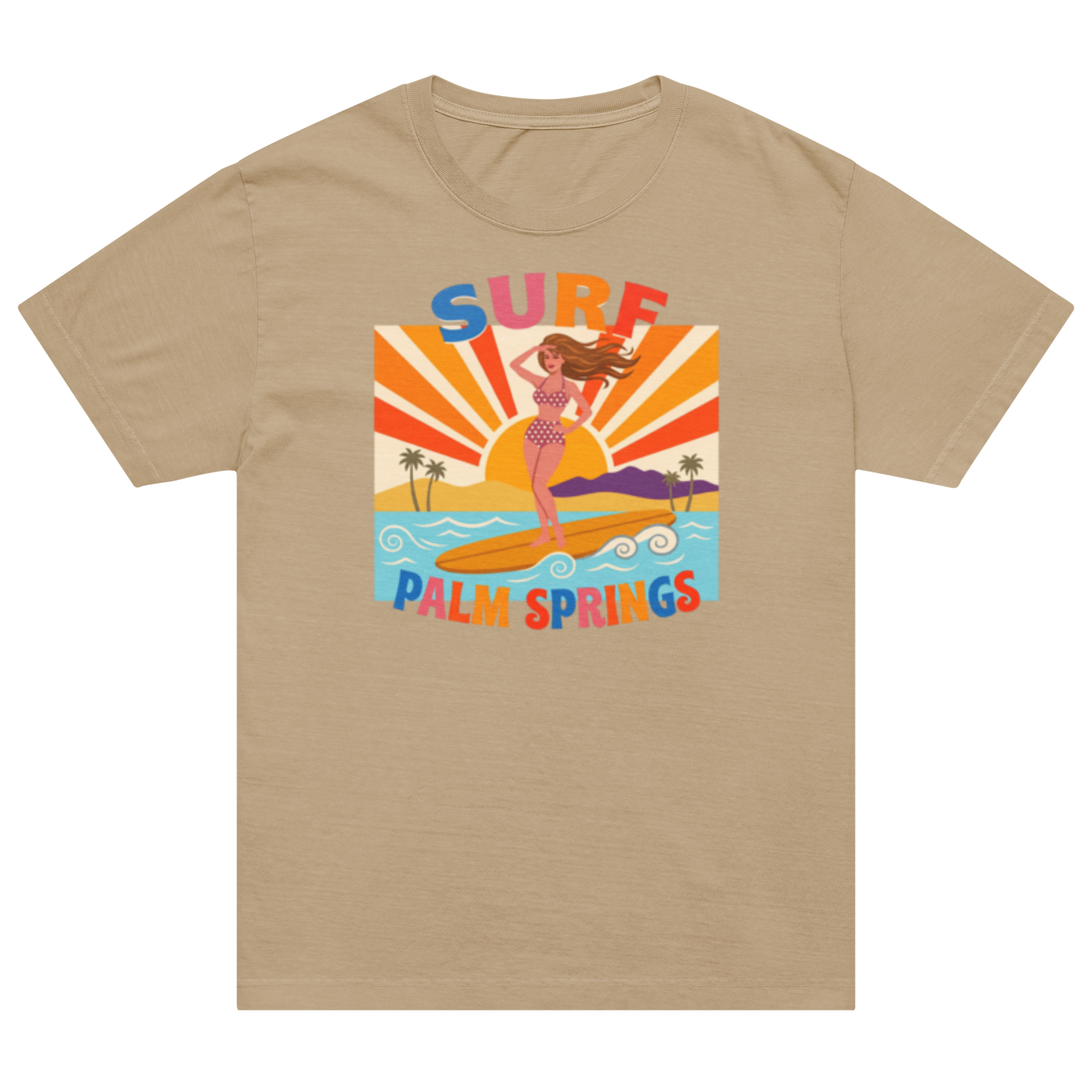 A beige crewneck t-shirt featuring a colorful retro graphic of a woman surfing on a beach with the text 'SURF PALM SPRINGS' in stylized lettering.