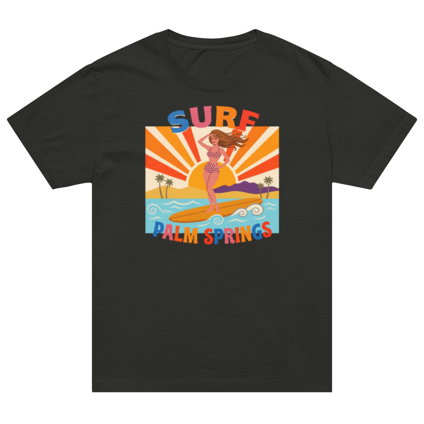 A black short-sleeve crewneck t-shirt featuring a colorful retro graphic of a woman surfing on a beach with a sunset, labeled 'SURF' and 'PALM SPRINGS'.