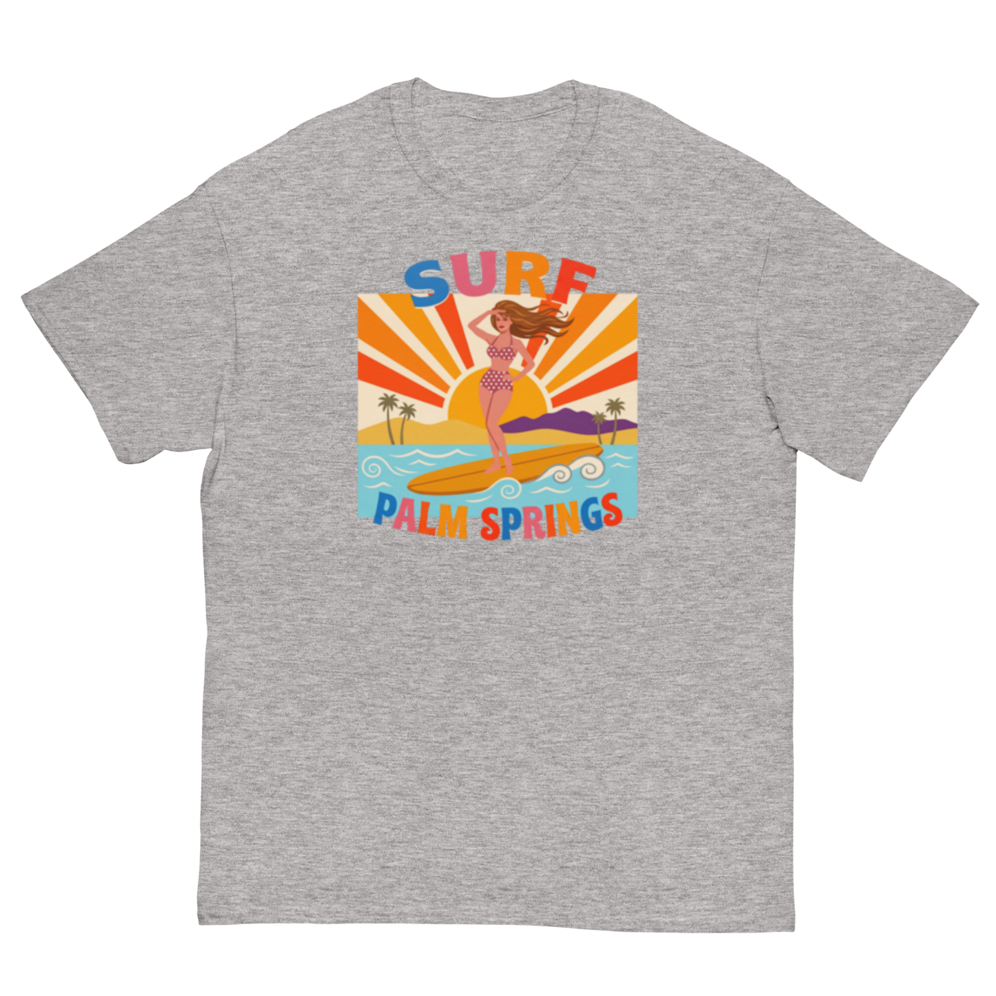 A heather gray crewneck t-shirt featuring a colorful retro graphic of a woman surfing on a beach with the text 'SURF PALM SPRINGS' in stylized multicolor lettering.