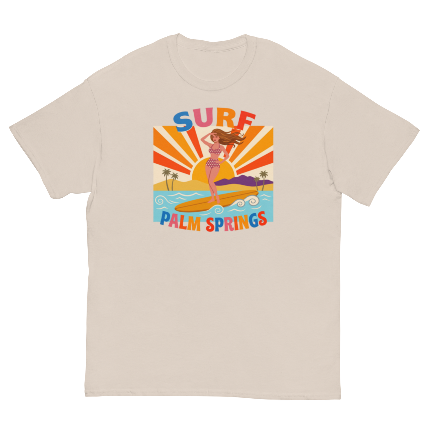 A light beige crewneck t-shirt featuring a colorful retro graphic of a woman surfing on a beach with the text 'SURF PALM SPRINGS' in stylized multicolor lettering.