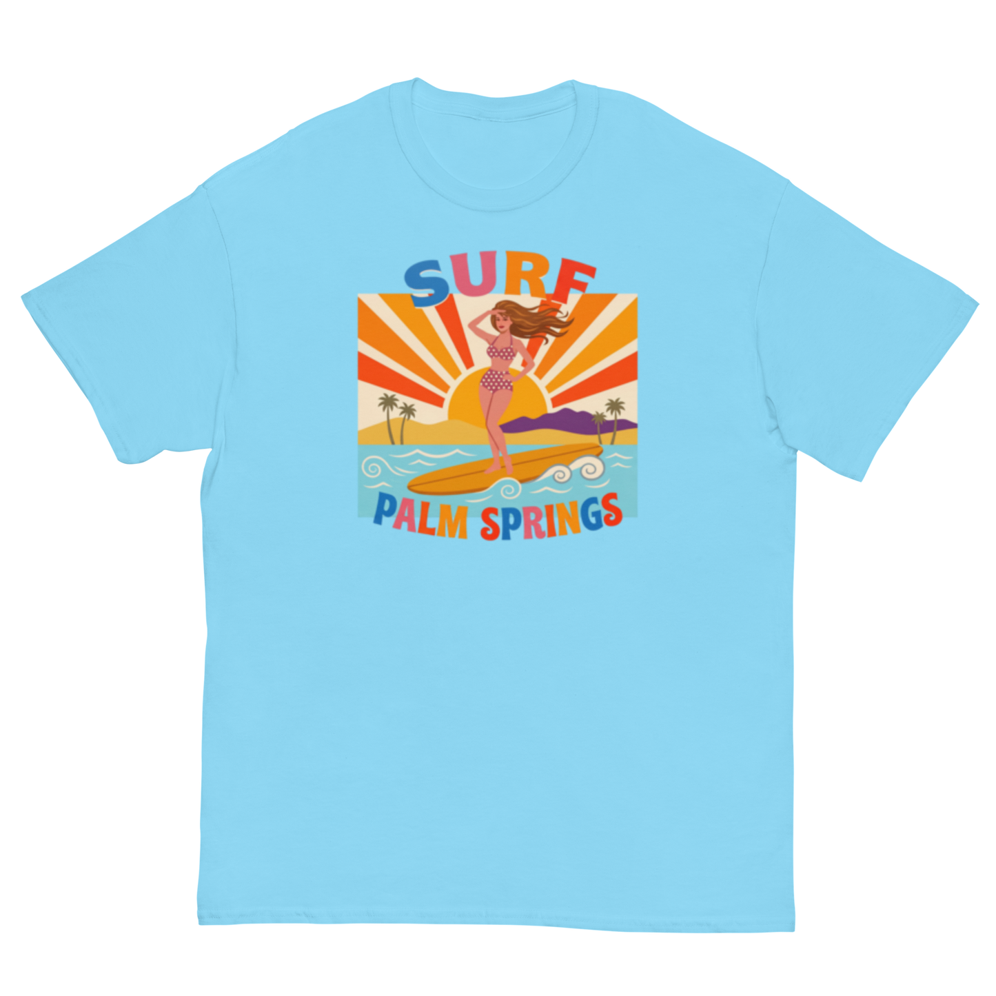 A light blue crewneck t-shirt featuring a retro-style graphic of a woman surfing on a yellow board with palm trees and the text 'SURF PALM SPRINGS' in colorful letters.