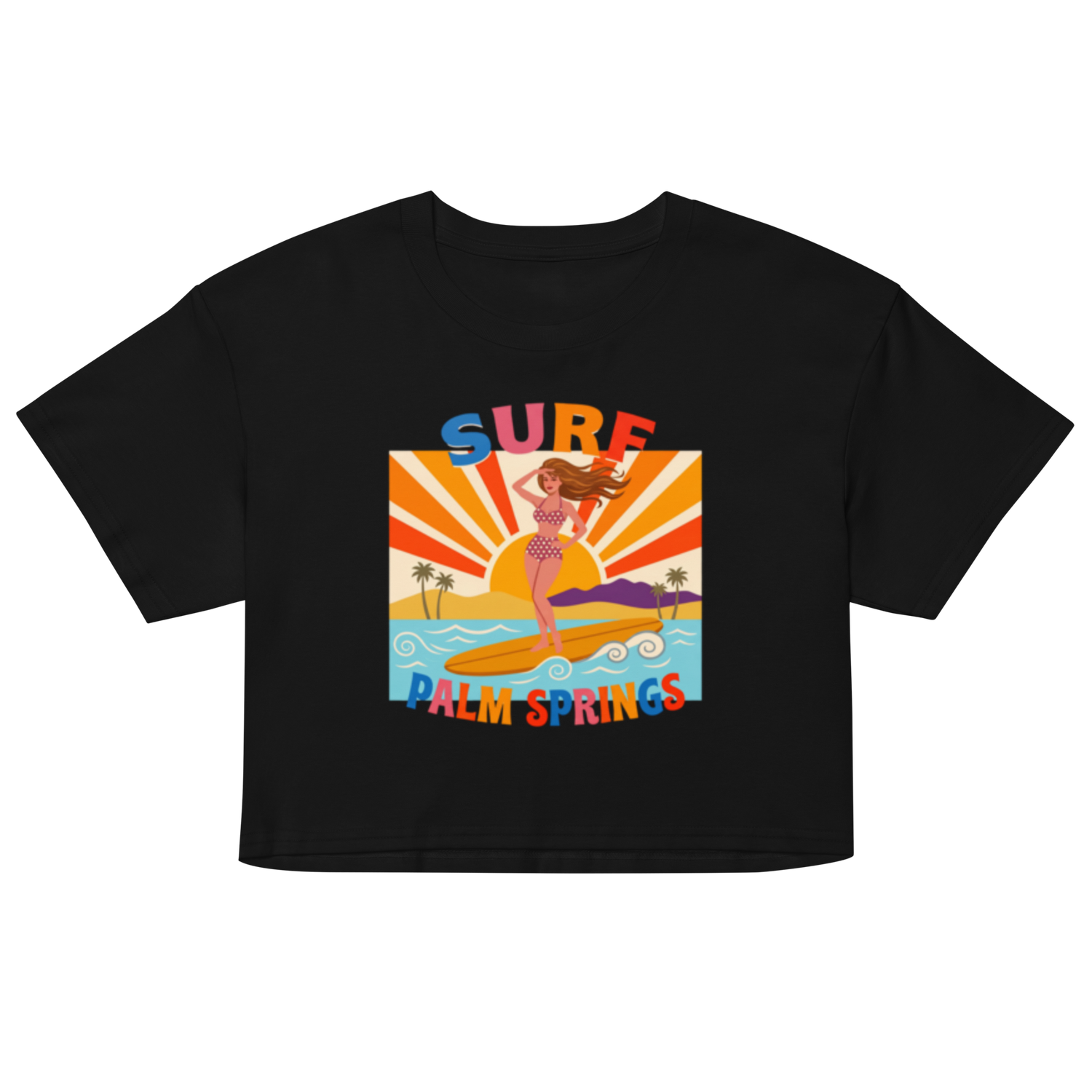 A black short-sleeve crop top t-shirt featuring a colorful retro graphic of a woman surfing on a palm beach with the text 'SURF' and 'PALM SPRINGS'.