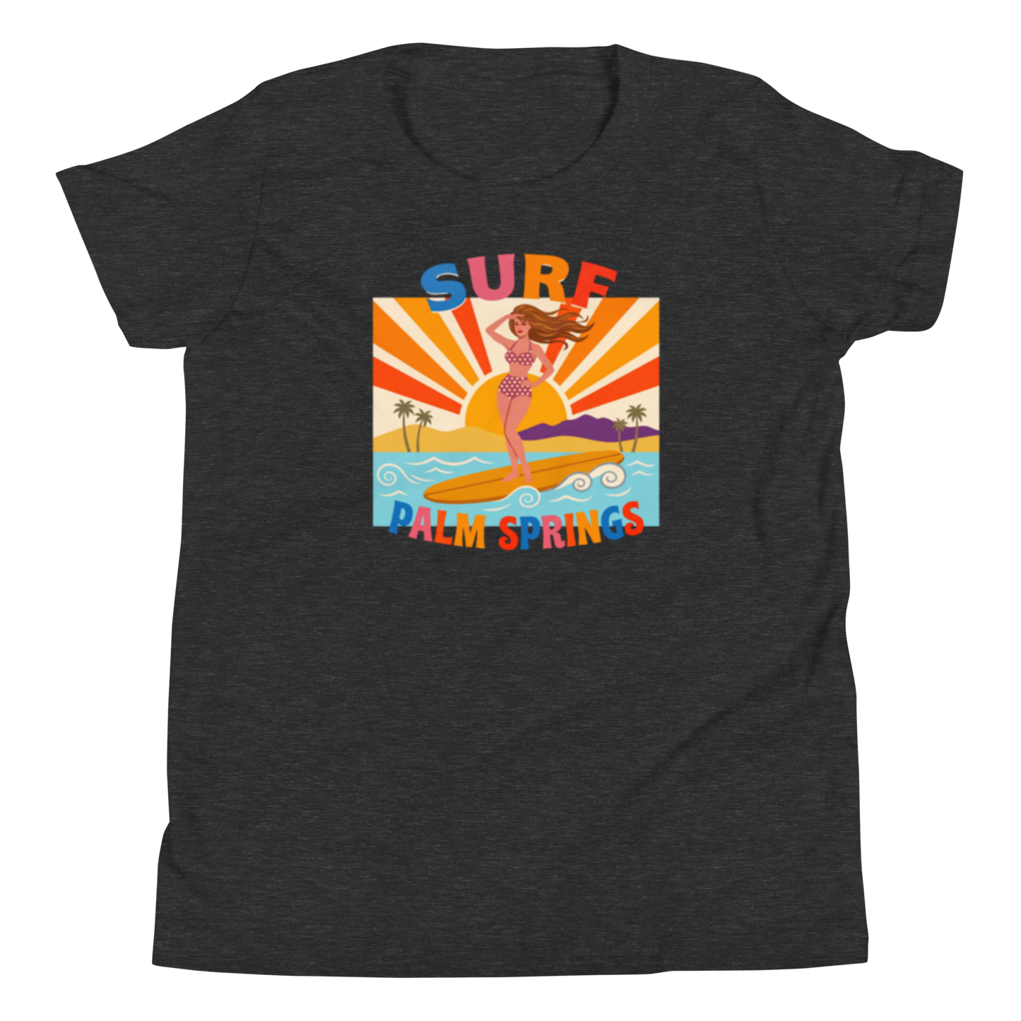 A dark heather gray women's short-sleeve t-shirt with a colorful retro graphic on the chest. The graphic features a woman surfing on a yellow board with palm trees, a sunburst background, and the text 'SURF PALM SPRINGS' in multicolored letters.