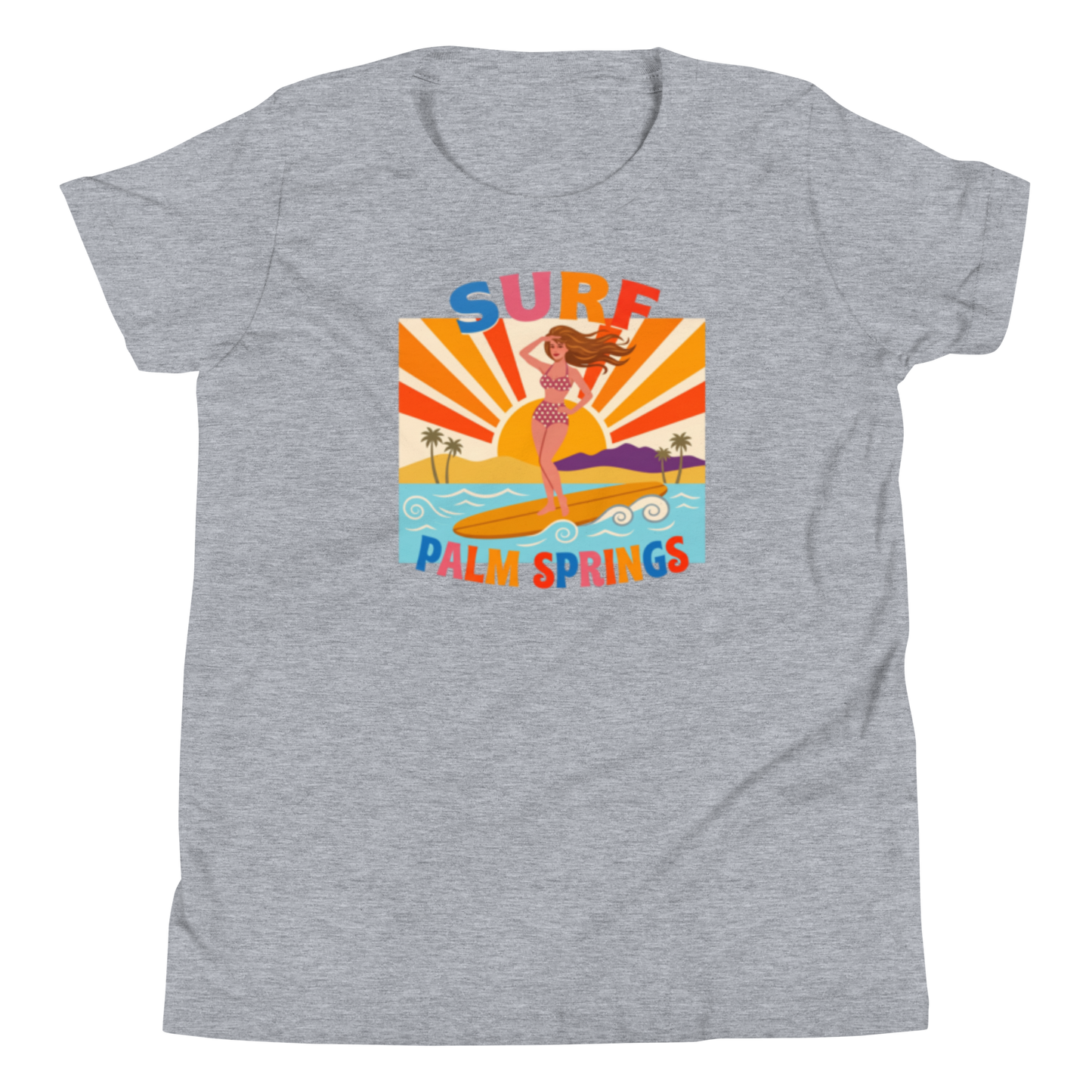 A heather gray short-sleeve t-shirt with a colorful retro graphic on the front. The graphic features a woman surfing on a yellow board with palm trees, a sunset, and the text 'SURF PALM SPRINGS' in stylized multicolor letters.