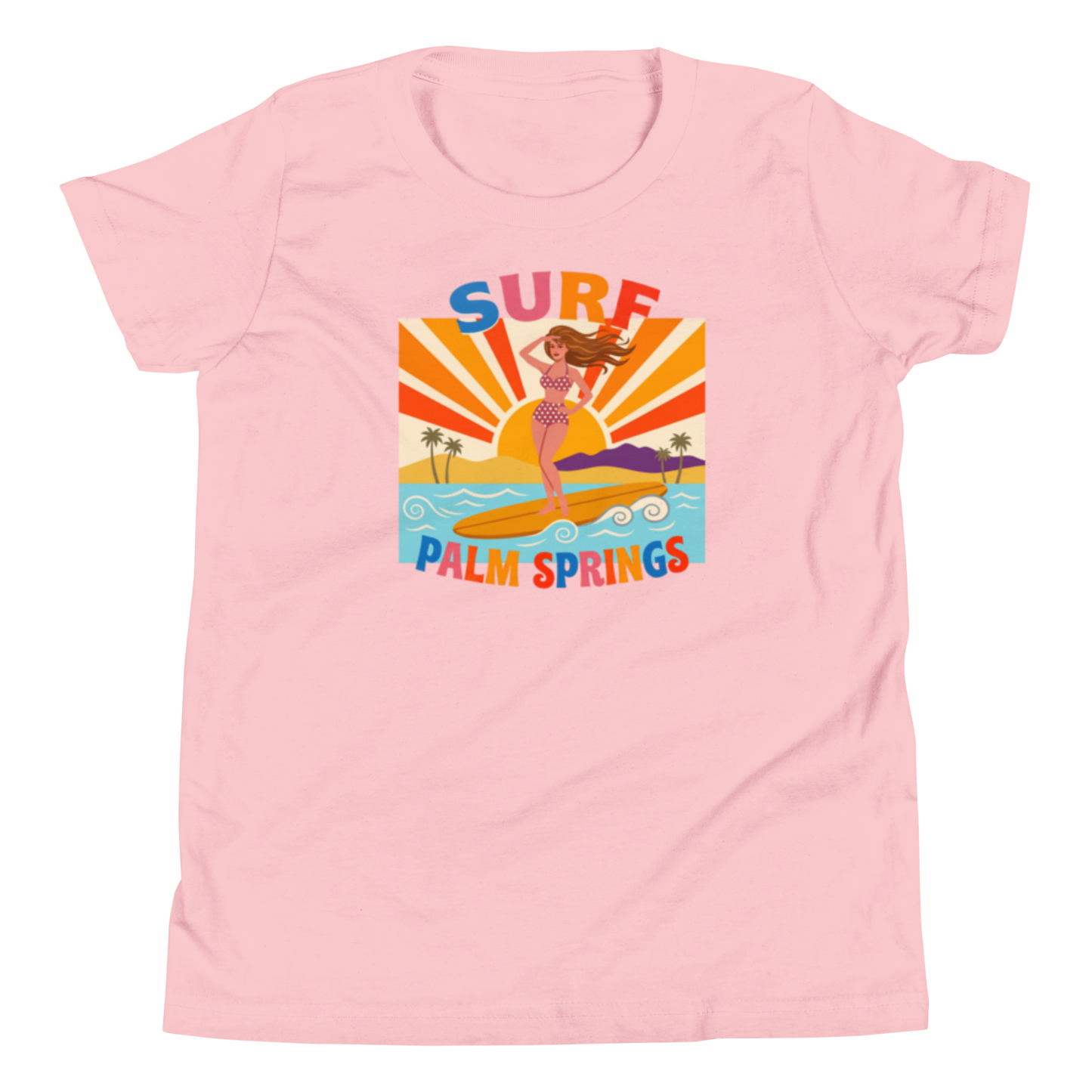 A light pink short-sleeve crewneck t-shirt featuring a colorful retro graphic of a mermaid surfing with the text 'SURF PALM SPRINGS' in stylized letters.