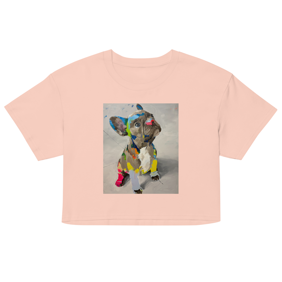 A light peach-pink short-sleeve crop top t-shirt featuring a square graphic print of a French Bulldog painted in a colorful, textured mosaic style, Daniel Maltzman design.