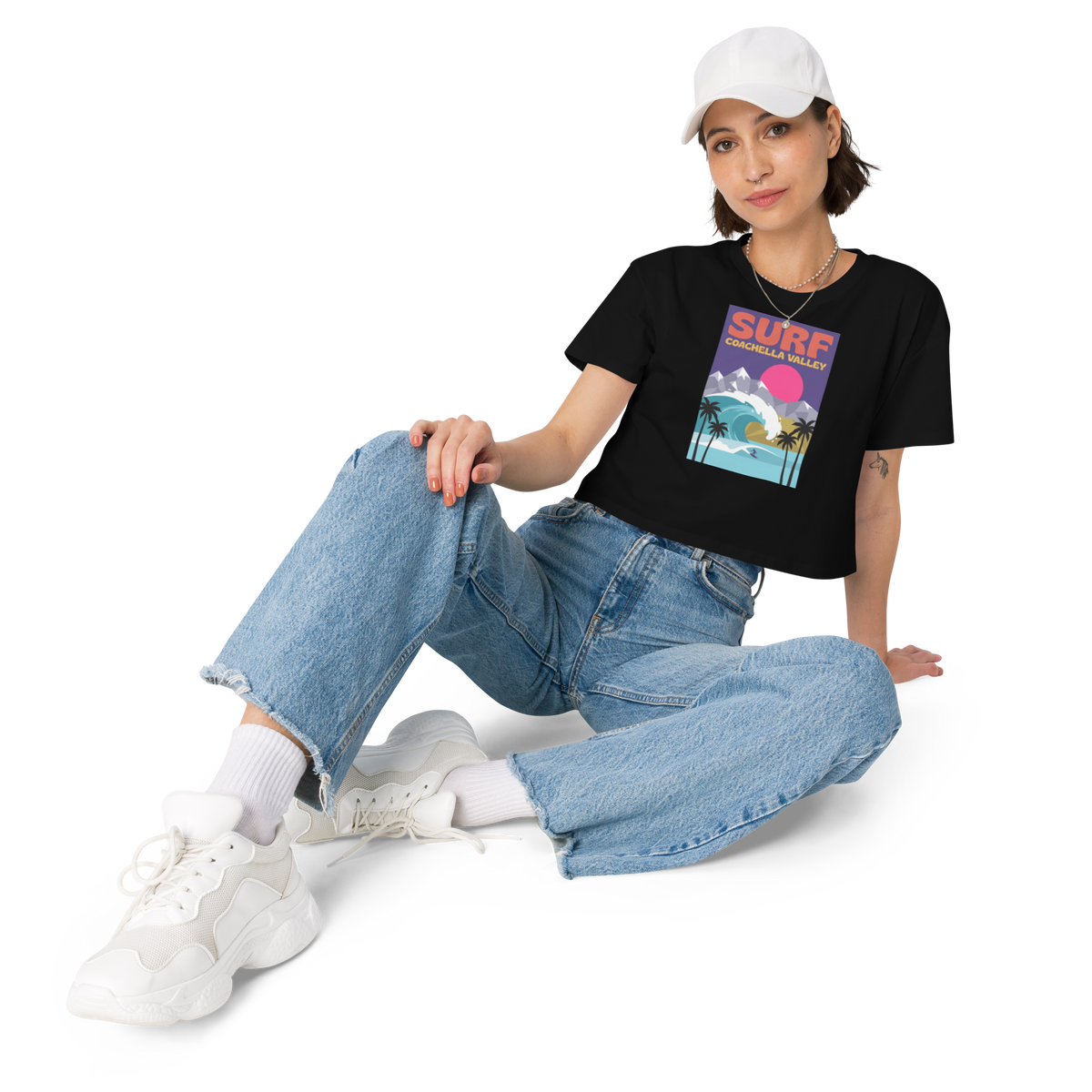 Person wearing a black t-shirt with a Coachella Valley Surf shirt sitting 