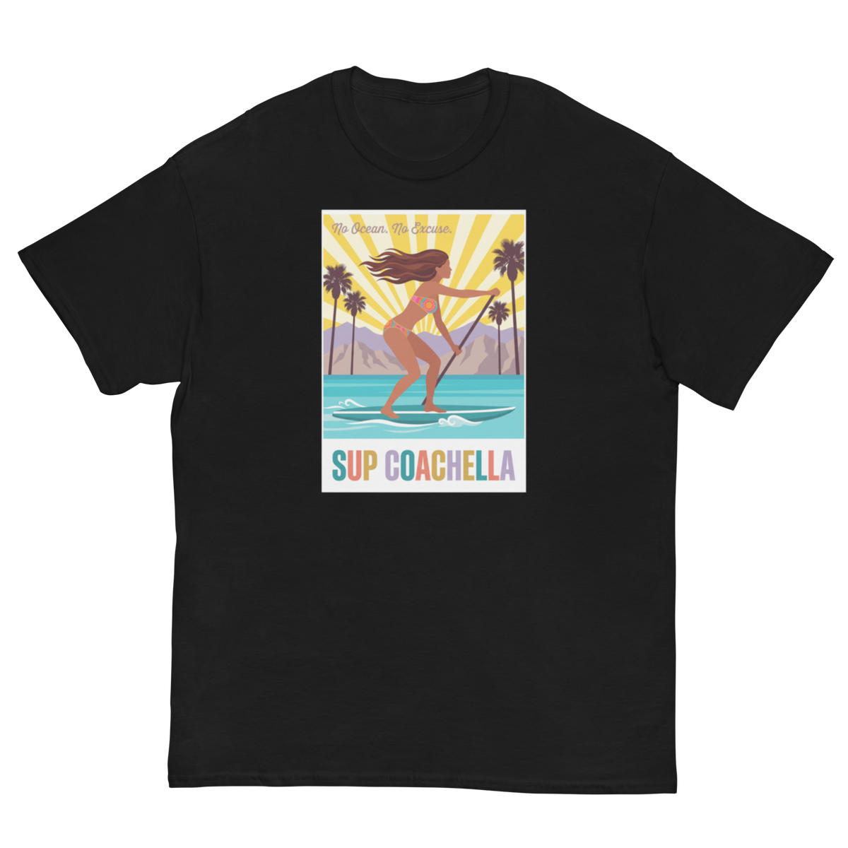 A black short-sleeve crewneck t-shirt featuring a colorful graphic print on the front. The graphic shows a woman stand-up paddleboarding on turquoise water with palm trees and mountains in the background under a yellow sunburst sky.