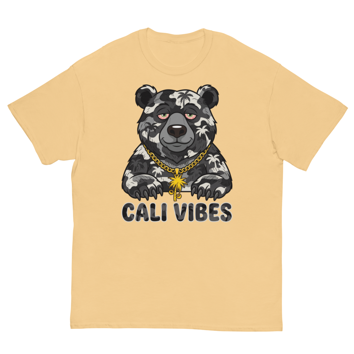 A light peach-colored short-sleeve t-shirt with a graphic of a black and white patterned bear wearing a gold chain necklace, above the text 'CALI VIBES'.