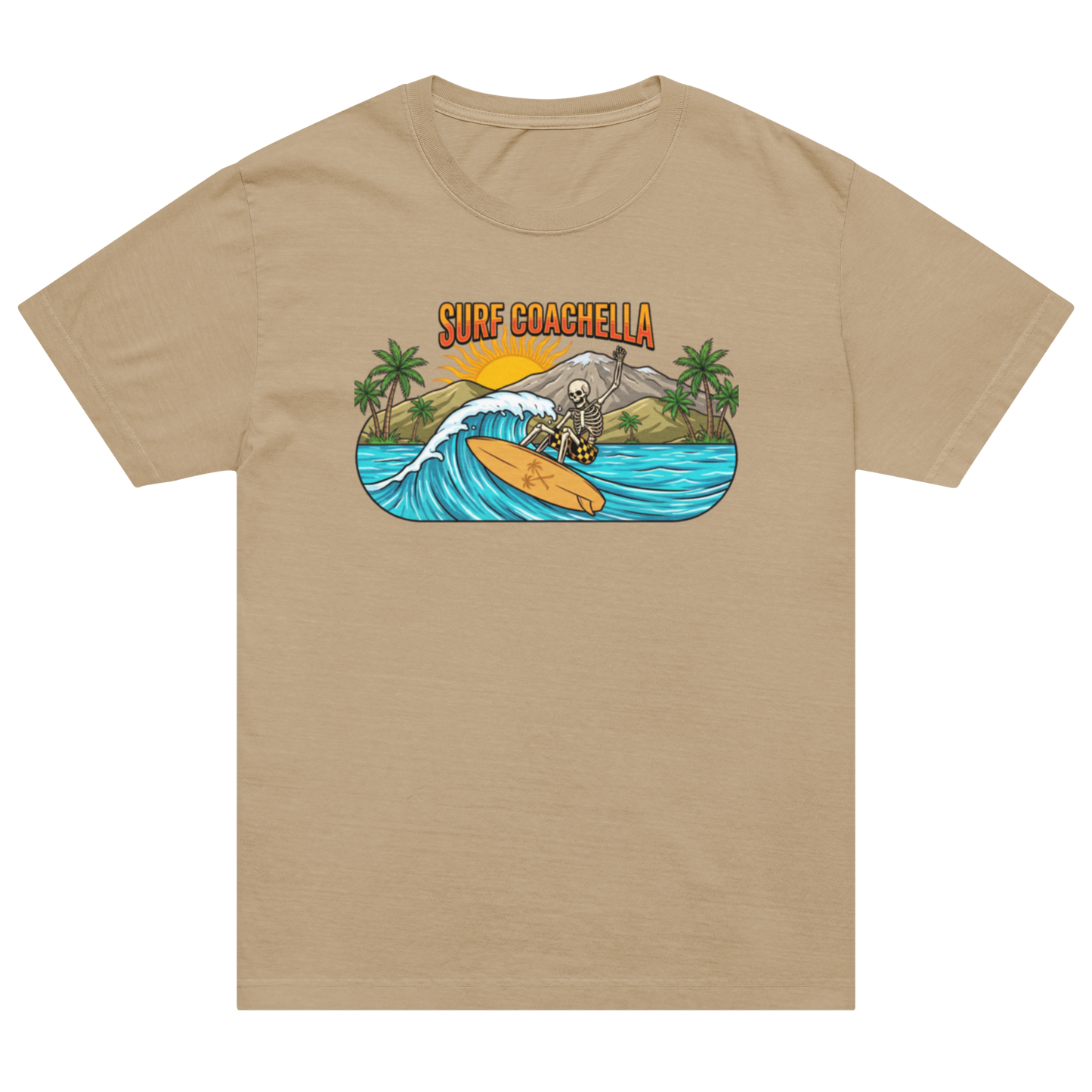 A tan short-sleeve crewneck t-shirt featuring a colorful graphic print on the chest. The graphic shows a surfer riding a wave on an orange surfboard with palm trees, mountains, and the text 'SURF COACHELLA' above it, set against a plain white background.