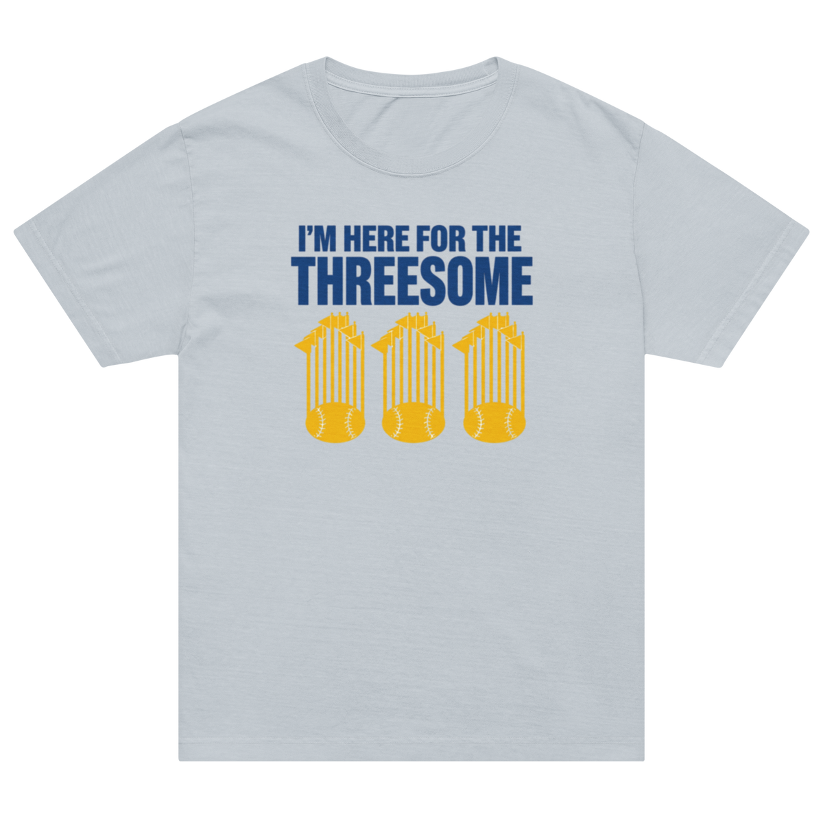 A light gray short-sleeve crewneck t-shirt featuring a graphic print on the front. The print displays the text 'I'M HERE FOR THE THREESOME' in dark blue, above three yellow silhouettes of baseball players in a crouched batting stance holding a baseball.