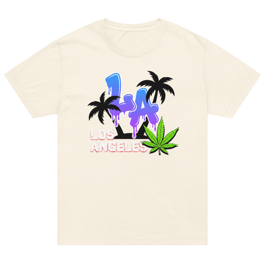 A cream-colored short-sleeve t-shirt with a colorful graphic on the front featuring the text 'LA LOS ANGELES' in a dripping neon style, flanked by black palm trees and a green cannabis leaf.