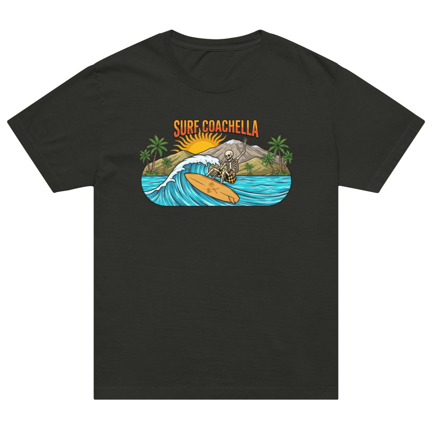 A black short-sleeve crewneck t-shirt featuring a colorful graphic print on the chest. The graphic shows a skeleton surfer riding a wave with palm trees, mountains, and a sun, with the text 'SURF COACHELLA' above it.