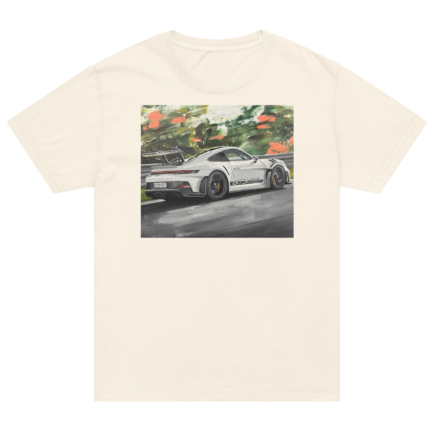 An off-white short-sleeve crewneck t-shirt featuring a rectangular graphic print of a white sports car on a racetrack with green foliage in the background. Daniel Maltzman artist.
