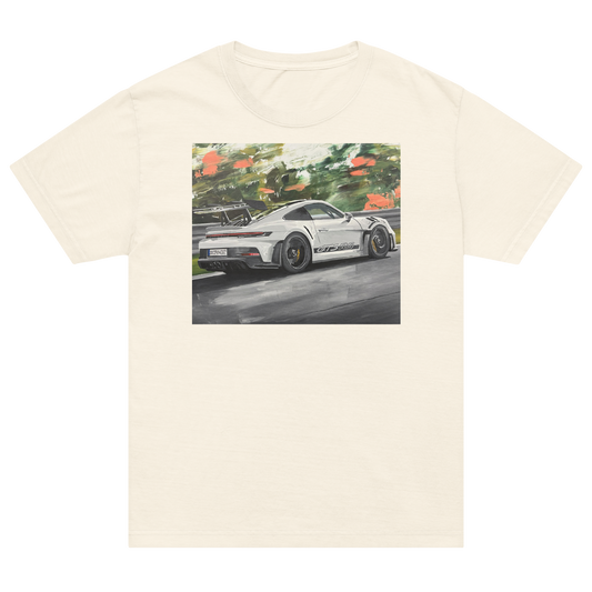 An off-white short-sleeve crewneck t-shirt featuring a rectangular graphic print of a white sports car on a racetrack with green foliage in the background. Daniel Maltzman artist.
