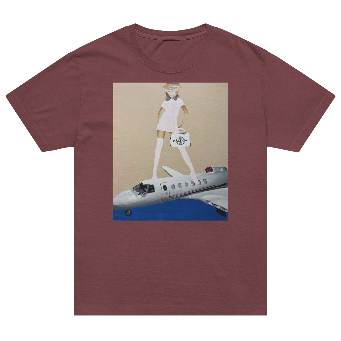 A heathered maroon short-sleeve t-shirt with a central graphic print showing a woman in a white dress standing on a silver airplane against a beige and blue background. Daniel Maltzman artist. 