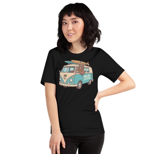 A woman modeling a black short-sleeve t-shirt with a colorful graphic of a retro 'Malibu California' van on the front, set against a plain white background.