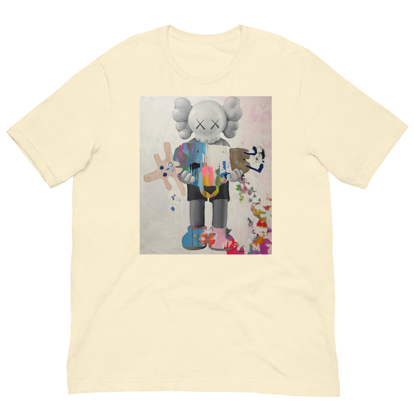 A pale cream-colored short-sleeve t-shirt featuring a large square graphic print of a stylized cartoon character resembling KAWS, holding a pink plush toy, displayed on a clean white background. Daniel Maltzman artist. 