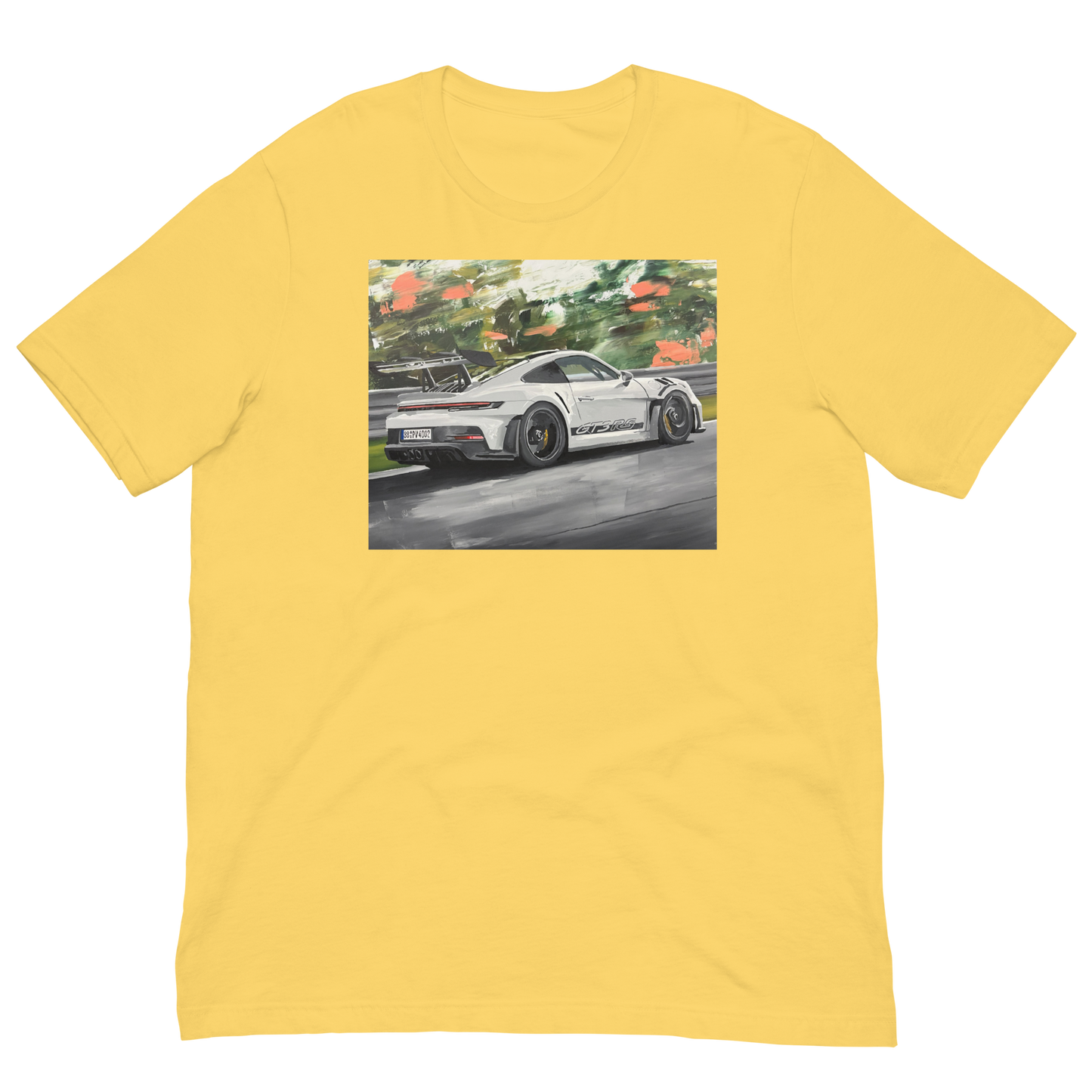 A yellow short-sleeve crewneck t-shirt featuring a rectangular graphic print on the chest of a white sports car on a racetrack surrounded by green trees. Daniel Maltzman original desgn.