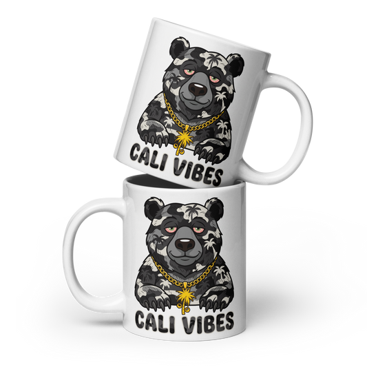 Two white ceramic mugs stacked with a cartoon bear graphic wearing a gold chain and the text 'CALI VIBES' printed on them, shown on a clean white background.