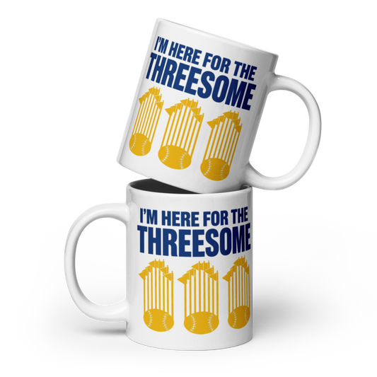 Two white ceramic mugs stacked with a humorous slogan and graphic design. The text reads 'I'M HERE FOR THE THREESOME' in bold blue letters, above three yellow baseballs inside yellow stadium stands.