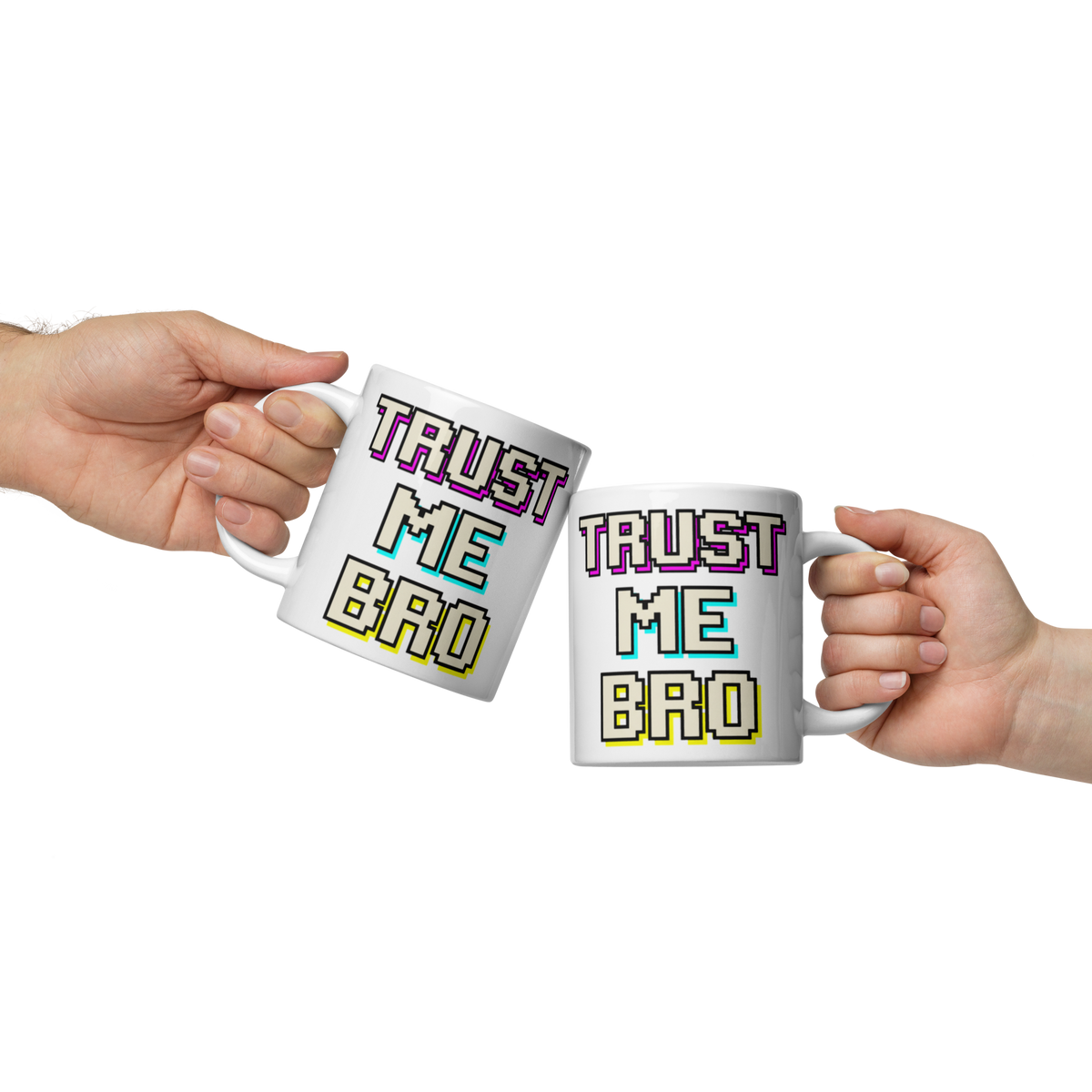 Two hands holding white ceramic mugs with the text 'TRUST ME BRO' in a pixelated retro font. The left mug has purple, teal, and yellow lettering, while the right mug has purple, cyan, and yellow lettering.