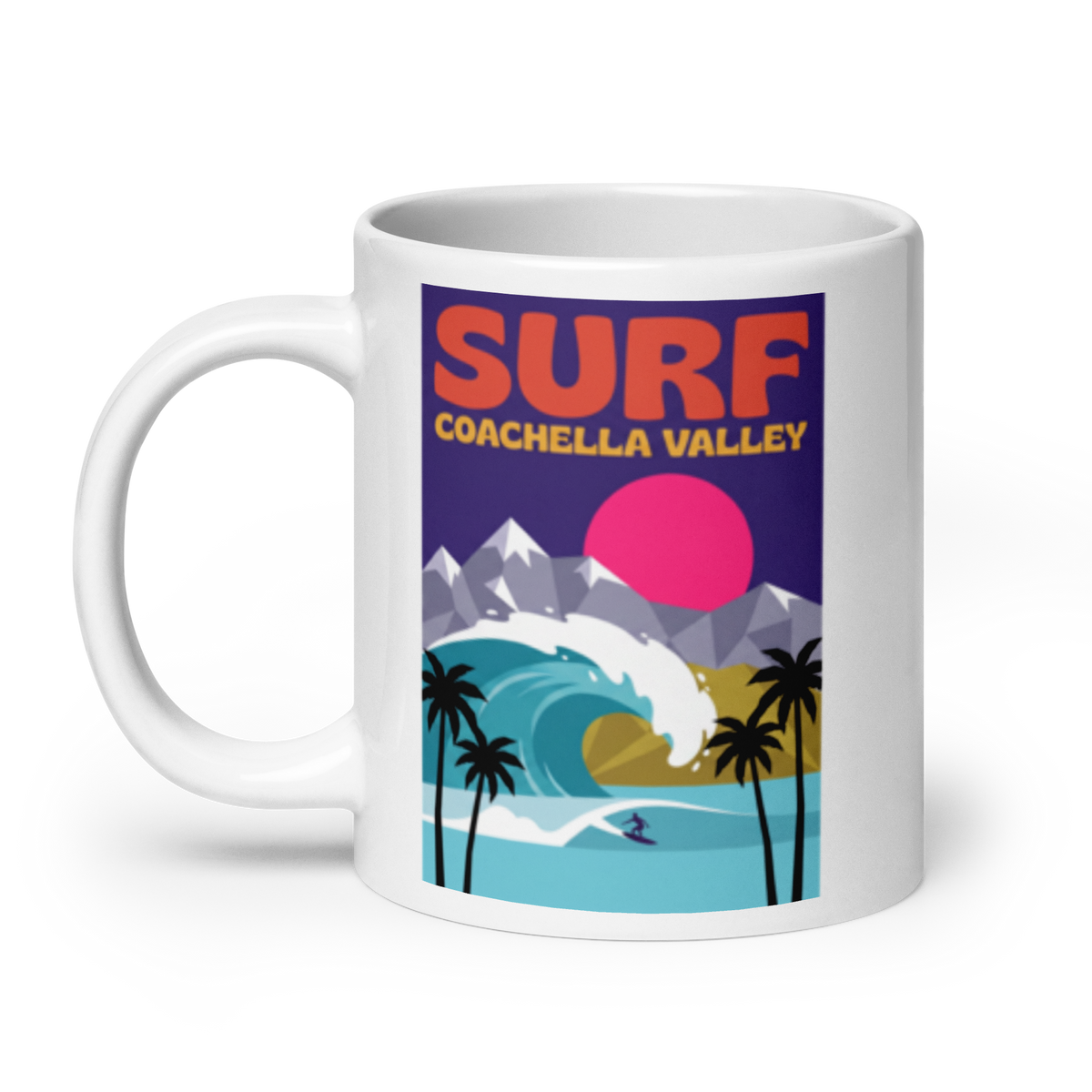 A white ceramic mug featuring a colorful retro-style graphic print with the text 'SURF COACHELLA VALLEY' above an illustration of a wave, mountains, palm trees, and a pink sun.