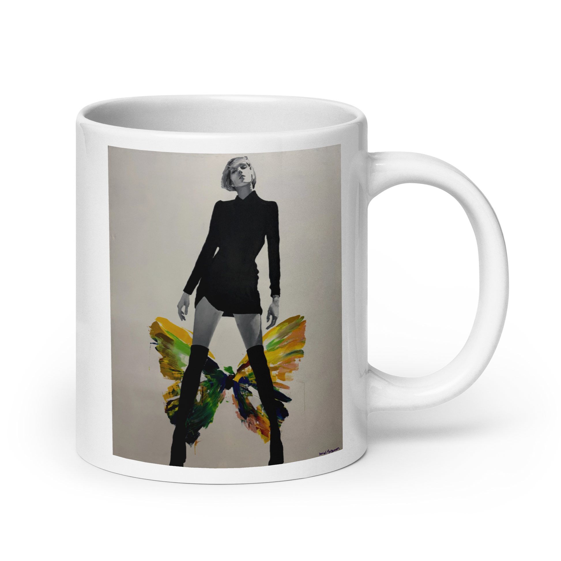 A white ceramic mug featuring a printed graphic of a woman in a black outfit with colorful butterfly wings, set against a plain white background. Daniel Maltzman artist.