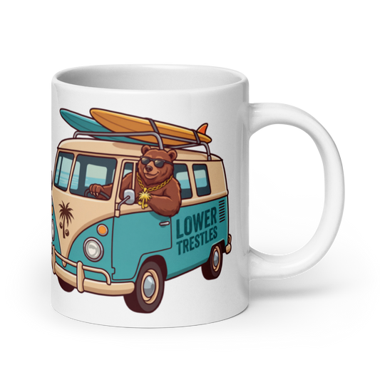 A white ceramic mug featuring a colorful cartoon illustration of a brown bear driving a beige and teal surf van with a surfboard on top. The side of the van reads 'LOWER TRESTLES'.